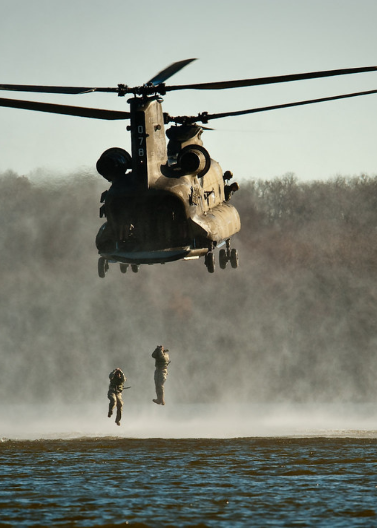 Two Cadets jumping out of a helicopter into Clinton Lake during the spring Helocast event